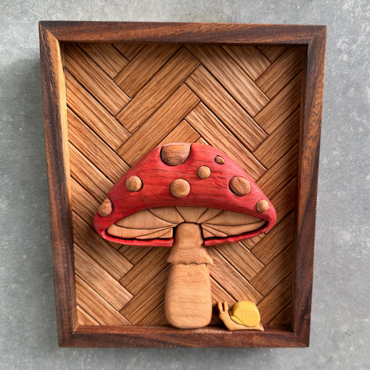 Wooden frame with a red mushroom-shaped object on a gray background